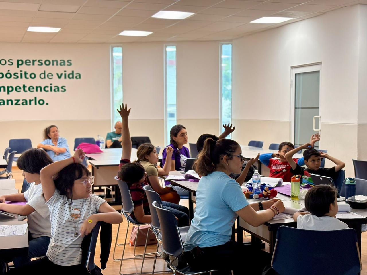 Salon con participantes levantando la mano
